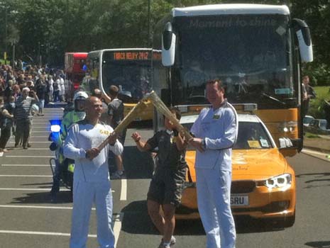 ...then passes the flame to the 2nd male bearer - the 5th bearer in the Relay
