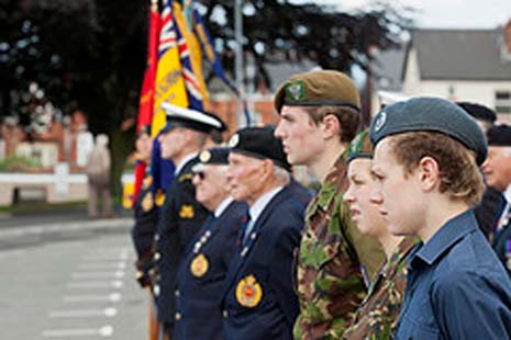 Cadets, servicemen and veterans stand shoulder to shoulder at the flag-raising ceremony that starts Armed Forces Week