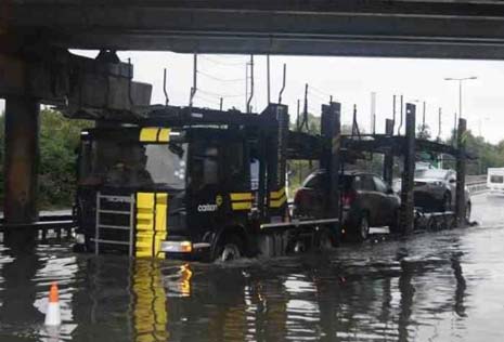 The flood water level can be clearly seen against this vehicle transporter at Horns Bridge