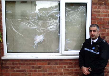 Officer Akeel Hussain next to the cracked window