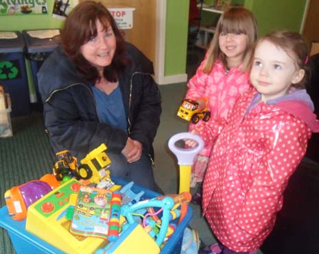 Donna Longden, Staveley Toy Library Co-ordinator is presented with the toys from Barlborough's Treetops Tots, Frankie and Sophie.