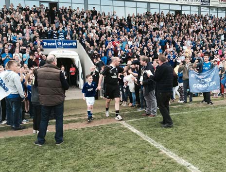 Manager Paul Cook comes back out with son Conor, to a rapturous reception from the sell out Proact crowd.