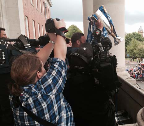 Everyone battles for a picture as the Trophy is finally held aloft to show the fans from the balcony of Chesterfield Town Hall.